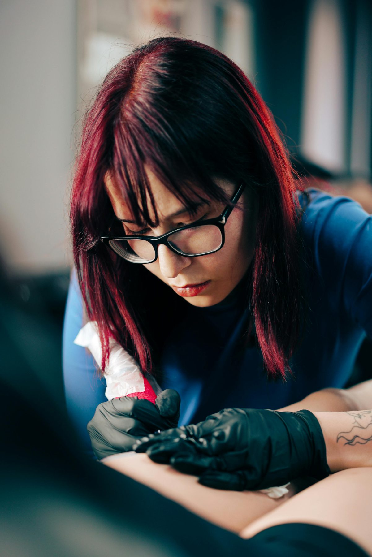 Jules Mercer, a Gilded Moth provider specializing in piercings, minimalist tattoos, and flash